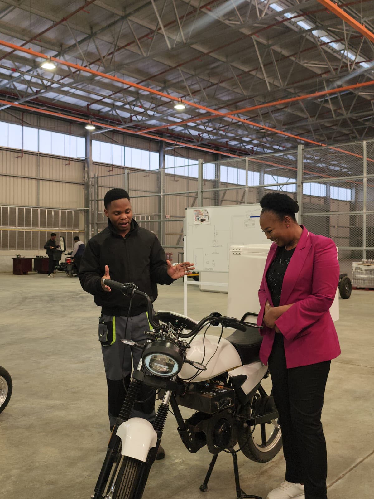 Technician explaining an electric bike build to a visitor
