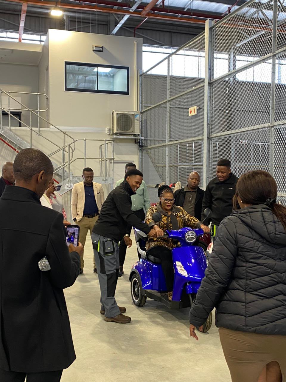 Guest test-riding a blue three-wheel mobility scooter